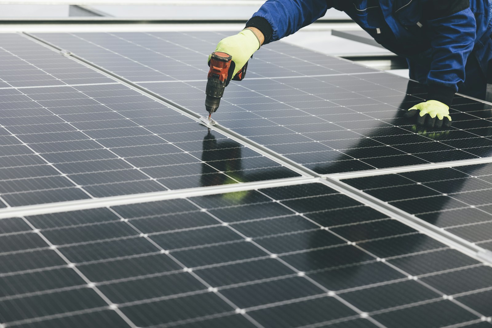 Técnico fixando placa solar com parafusadeira